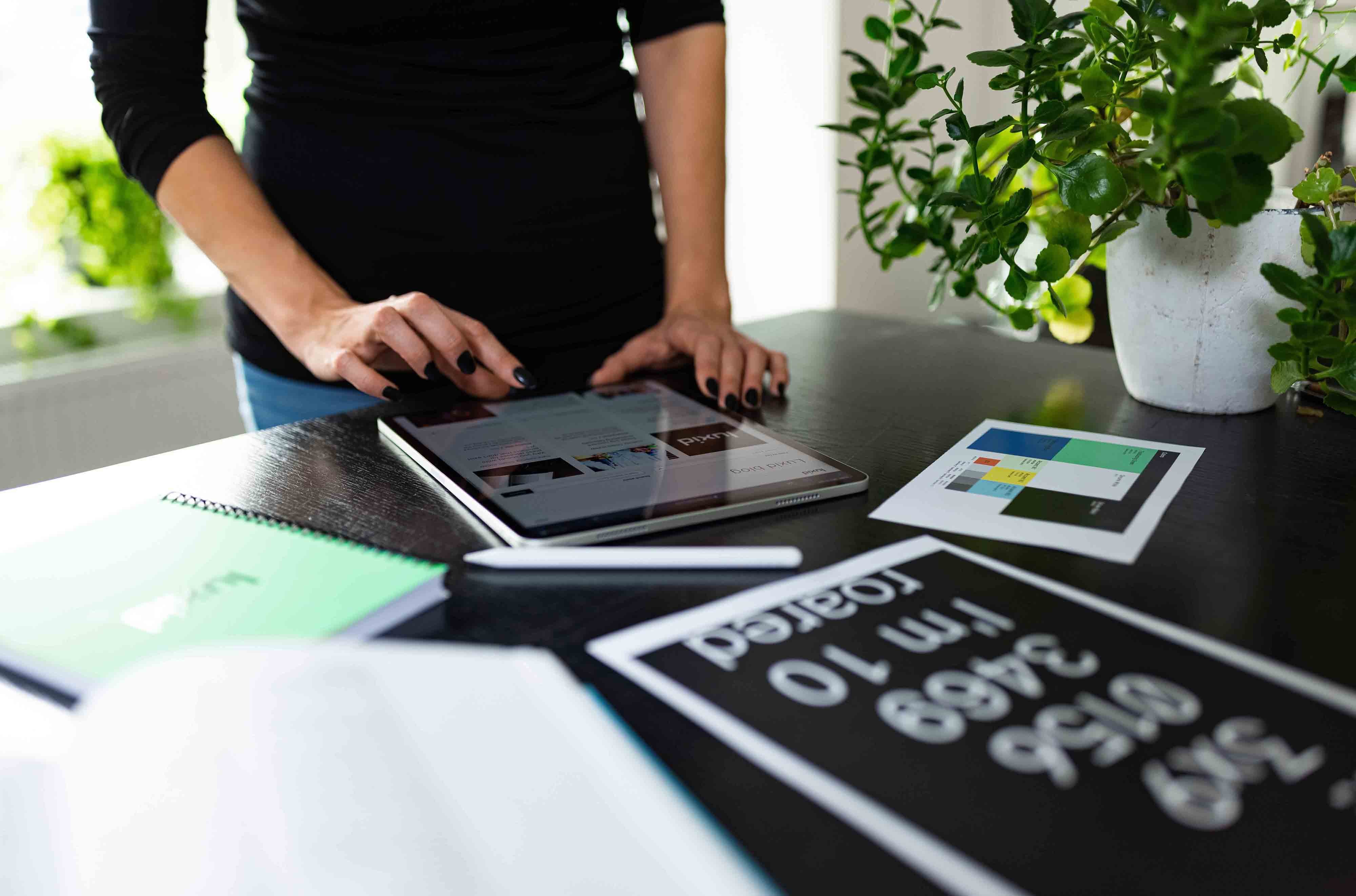 office-woman-tablet-stationery-plant