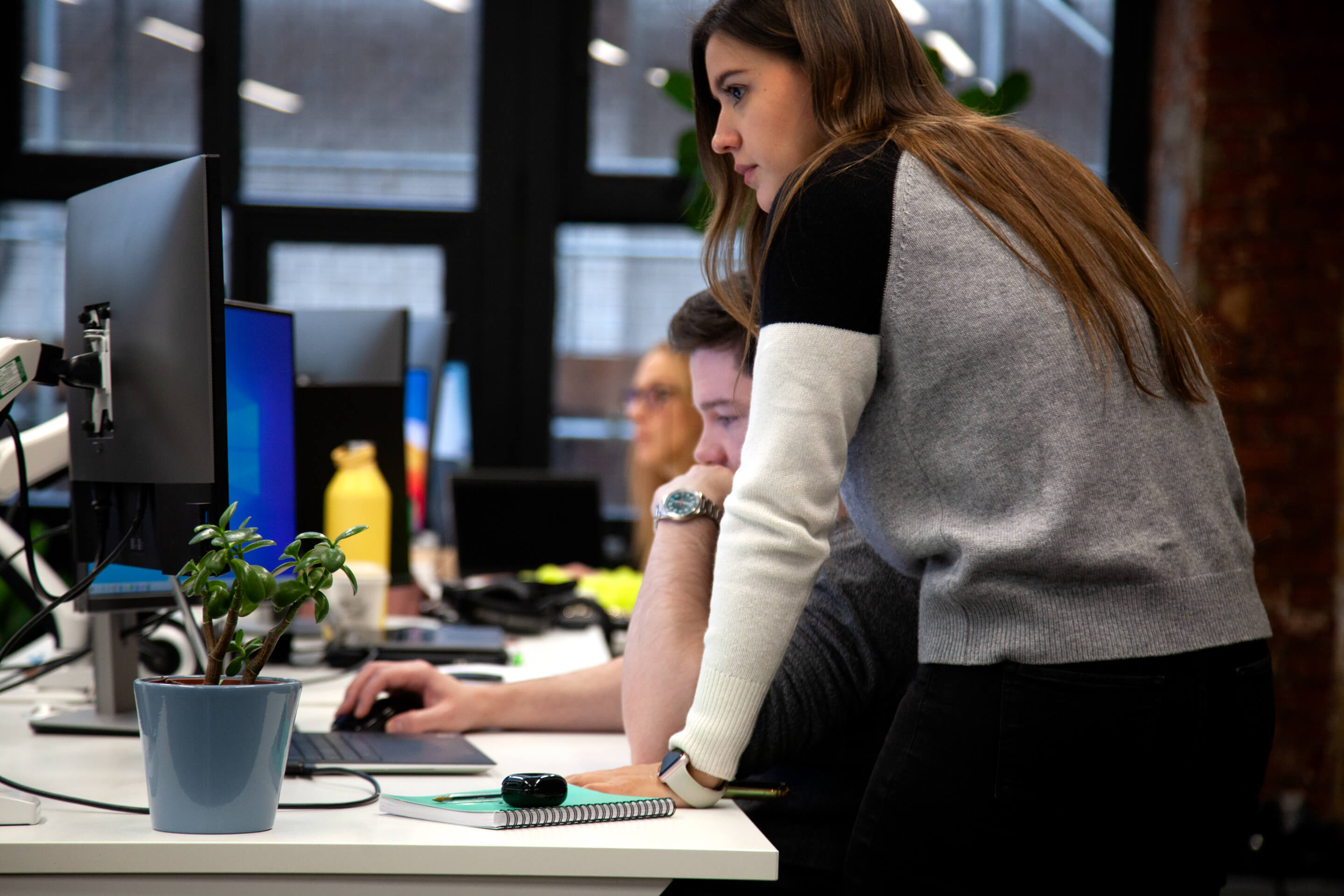 latin-woman-and-white-man-working-in-office-looking-at-computer