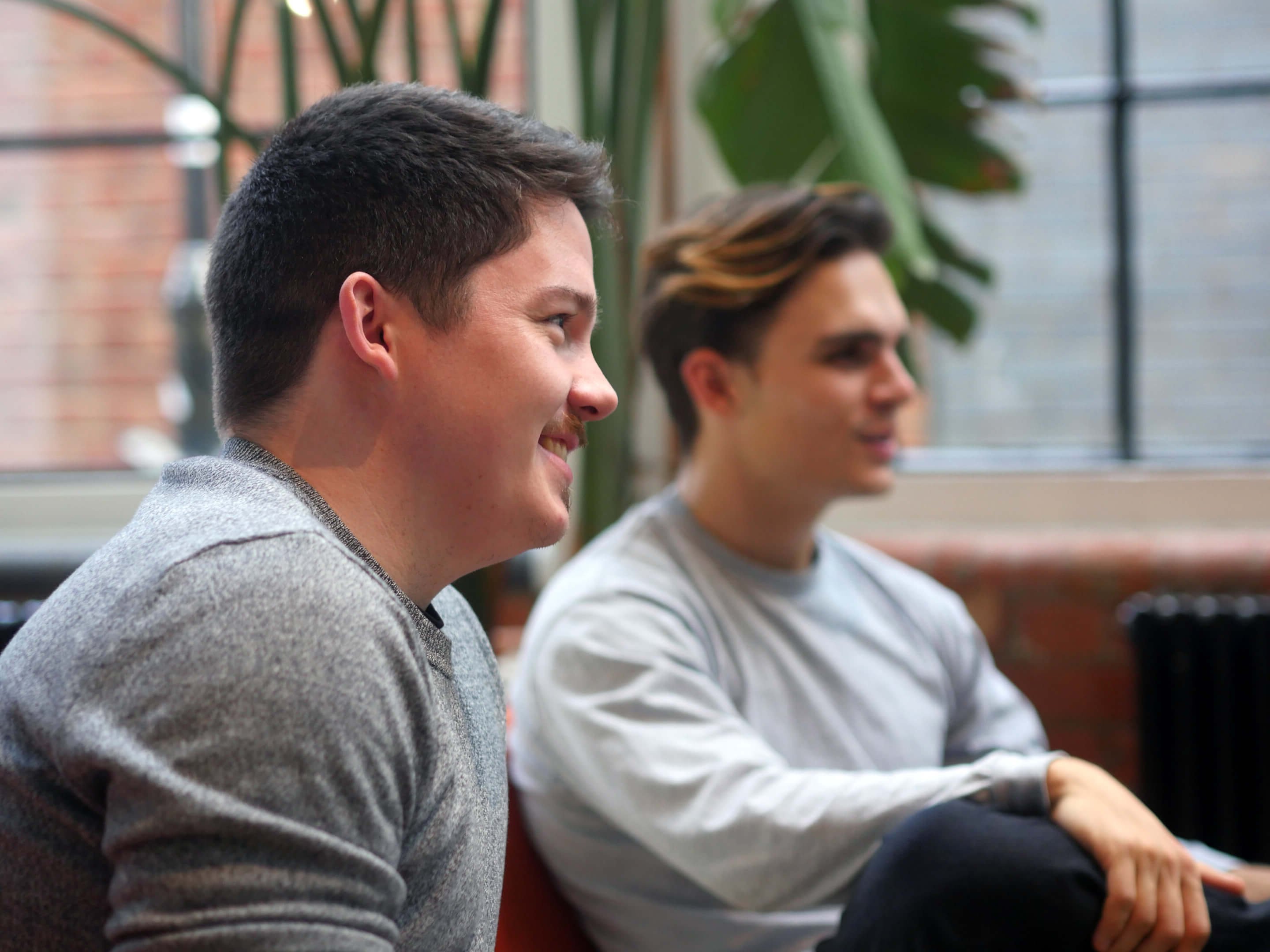 two young men sitting talking