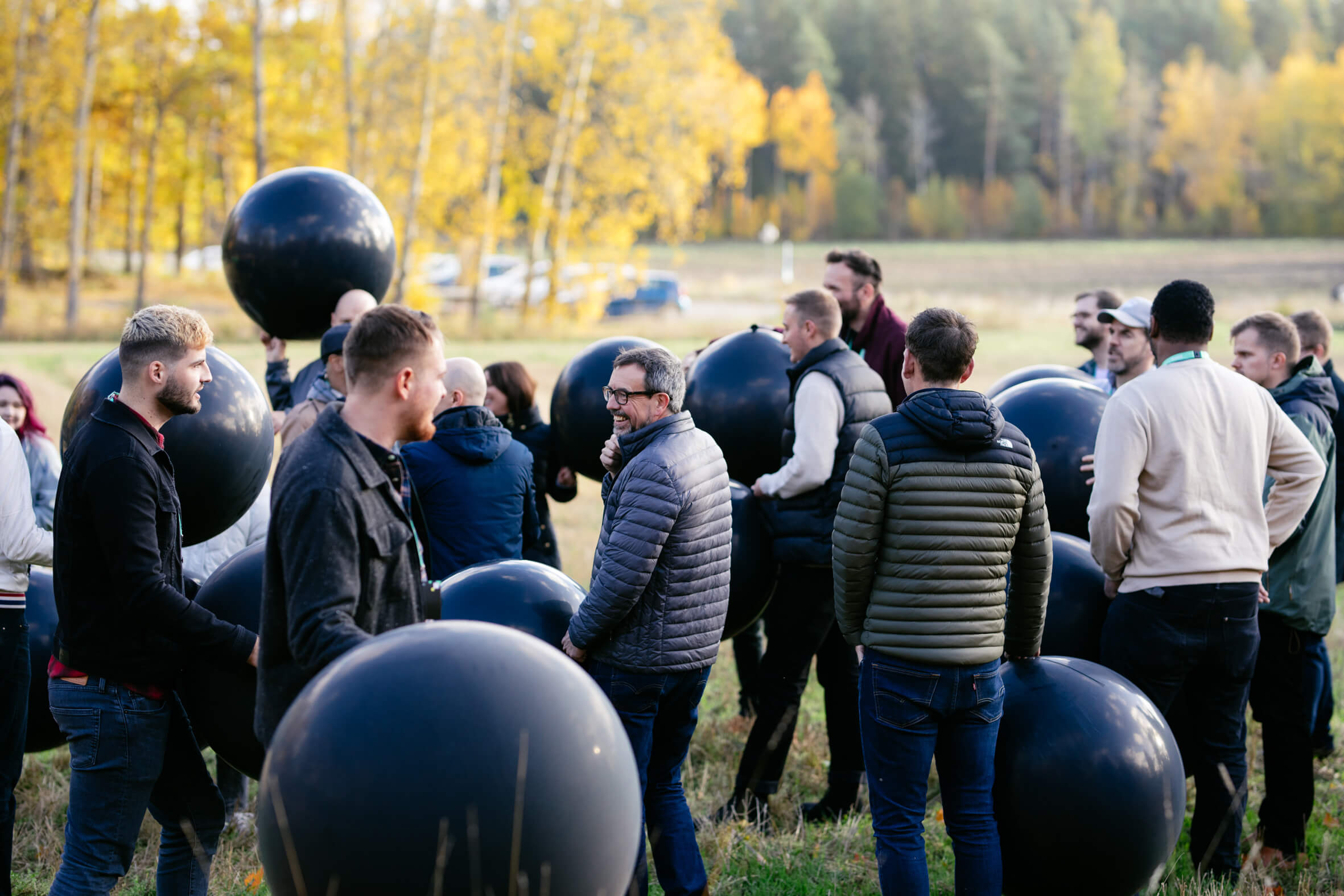 people-outdoors-team-building-activity-with-black-balloons