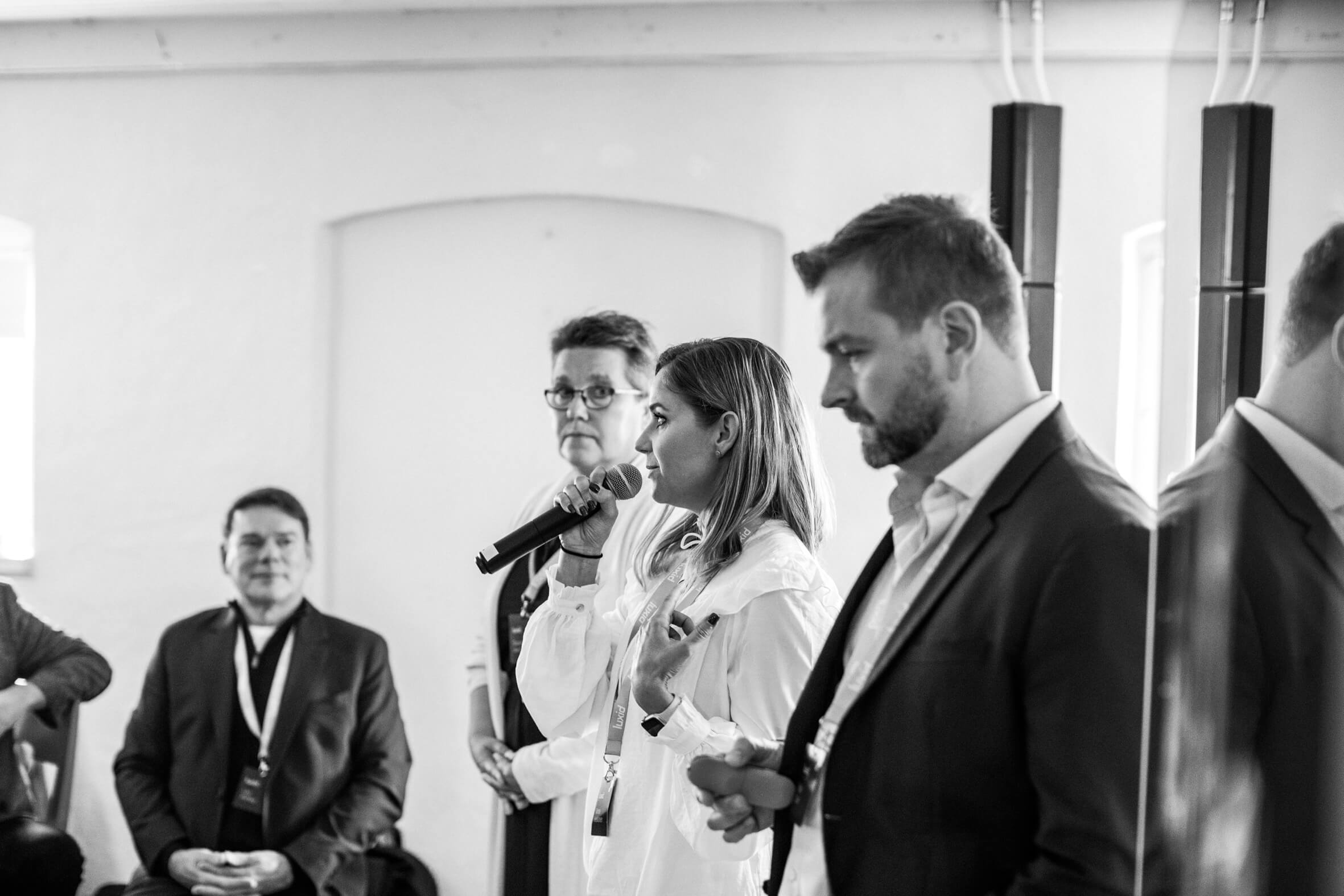 woman giving speech next to other woman and man