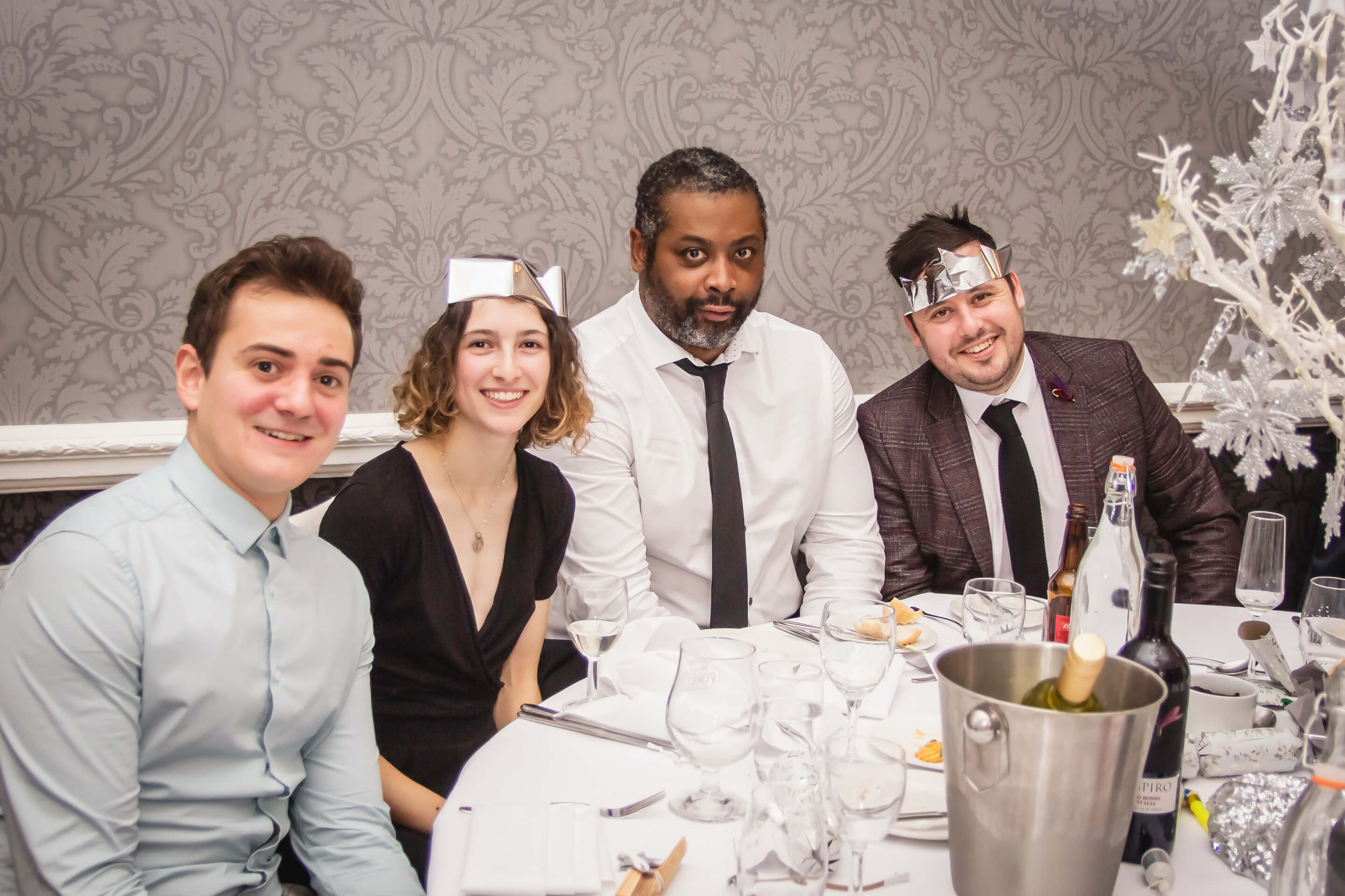 three-men-one-women-sitting-at-round-table-christmas-dinner