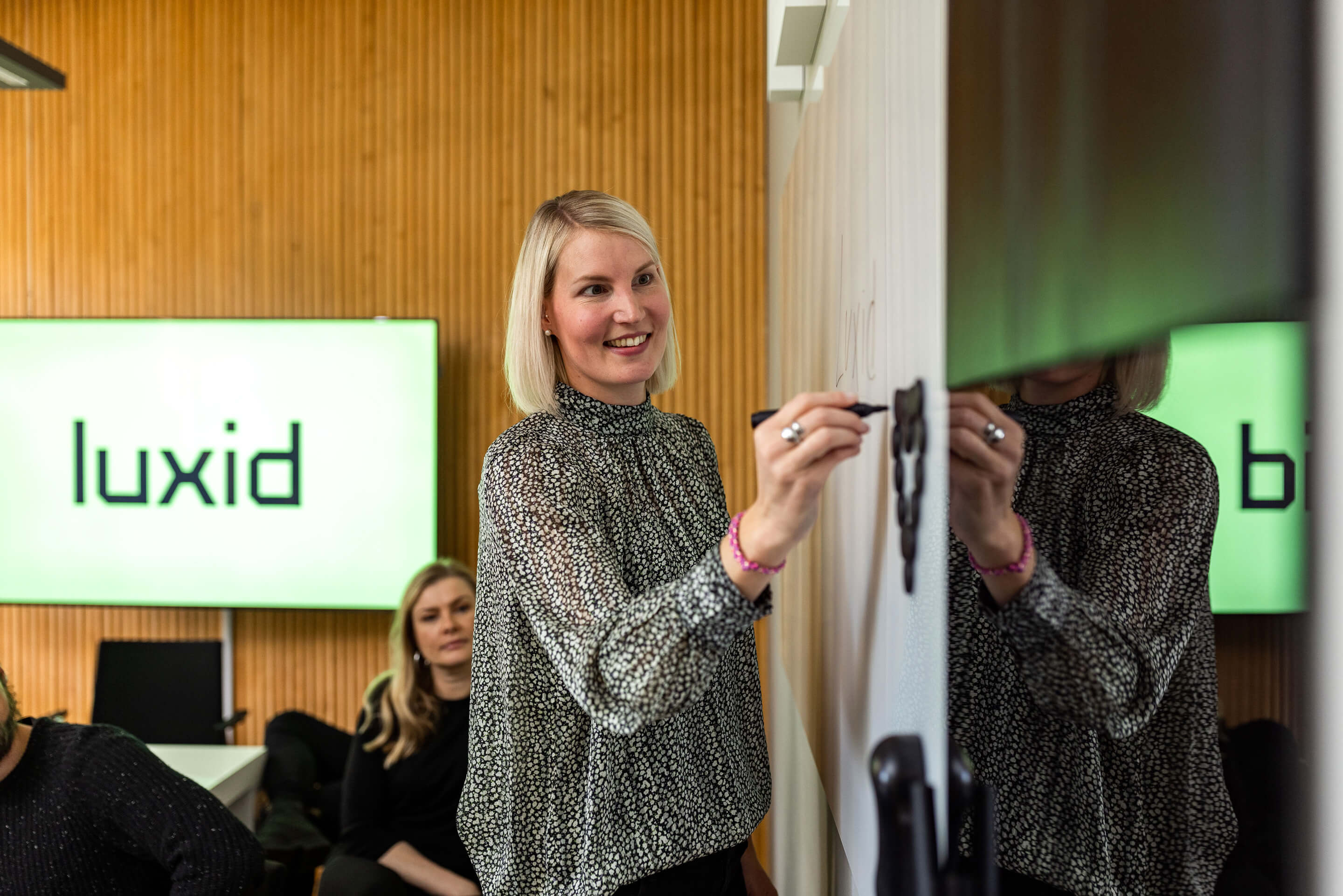 woman-luxid-office-writing-on-whiteboard