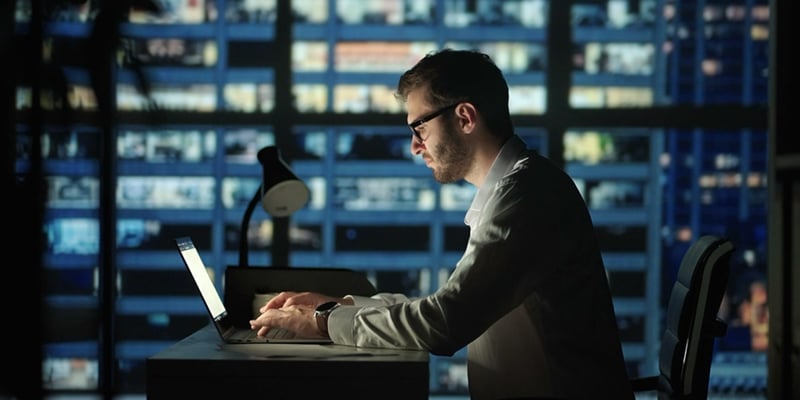 Man behind laptop in office building